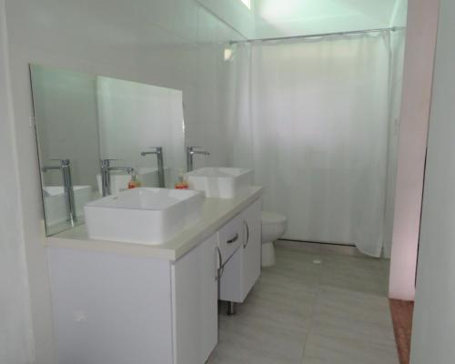 a white bathroom with two sinks and a shower at HOTEL PURA VIDA in Santa Rosa de Cabal