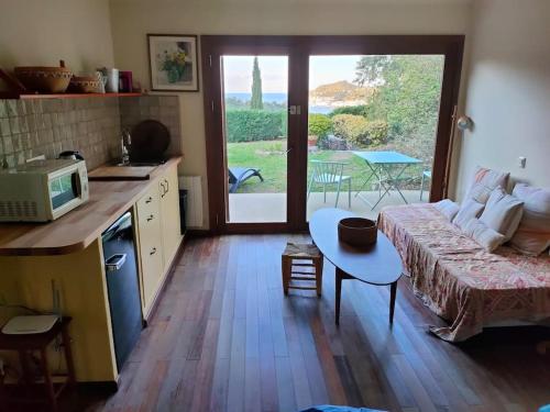 cocina y sala de estar con sofá y mesa en Cap de Creus : bungalow, jardin y vista al mar. en Selva de Mar