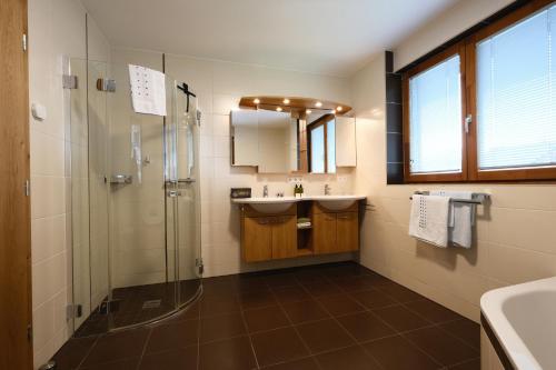 a bathroom with a glass shower and a sink at See-Apartments Kärntnerhof in Weissensee