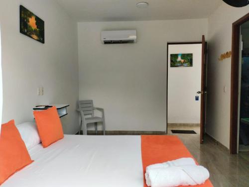 a bedroom with a large white bed with orange pillows at La Rivera Playa Palomino in Palomino