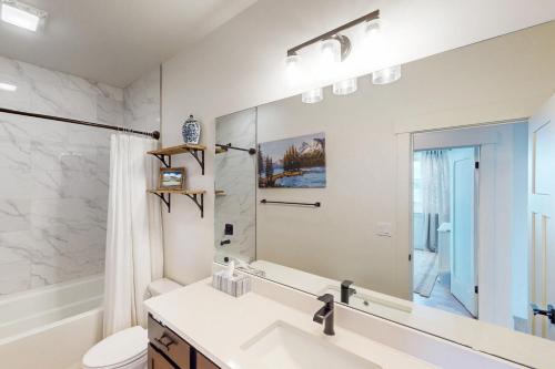 a bathroom with a sink and a large mirror at Blue Skies Over Butler Creek in Belgrade