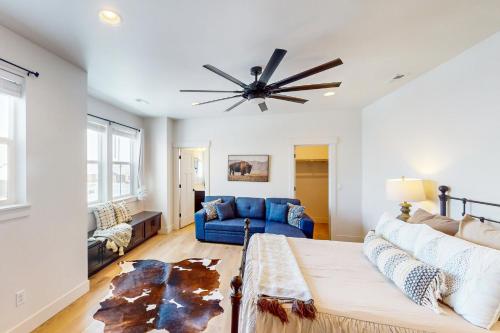 a living room with a blue couch and a ceiling fan at Blue Skies Over Butler Creek in Belgrade