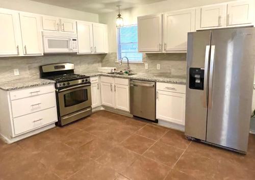 a kitchen with white cabinets and a stainless steel refrigerator at Private Room near downtown Dallas42 in Dallas