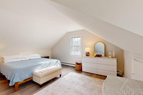 Un dormitorio con una cama y una cómoda y una ventana. en Sand Dollar Dreams, en Harwich