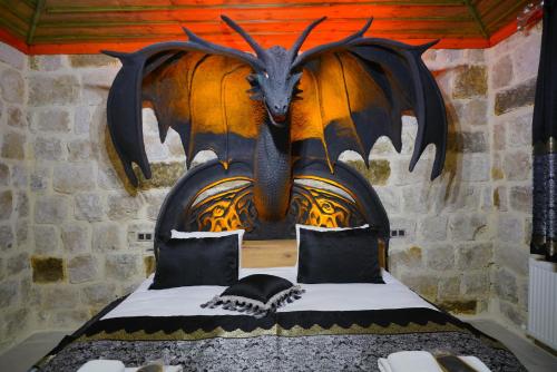 una cama con una cabeza de dragón en una pared en Kayatas Cave Suites, en Göreme