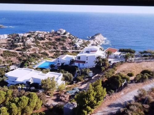 an aerial view of a house on a hill with the ocean at Bellevue Village ''Αdults Only'' in Agia Pelagia