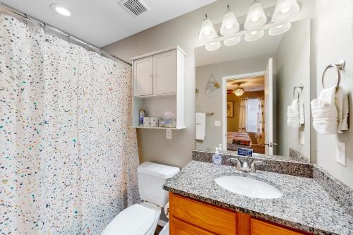 een badkamer met een toilet, een wastafel en een douche bij Whimsy on the Hillside in Branson