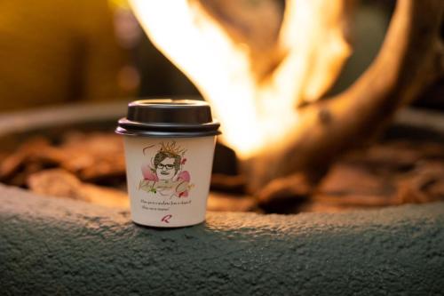 a cup of coffee sitting in front of a fire at Rafain Palace Hotel & Convention Center in Foz do Iguaçu