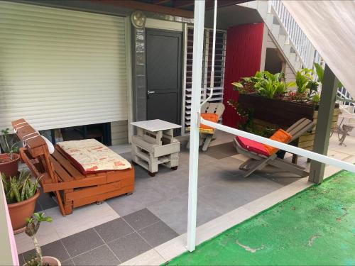 a patio with a table and chairs on a porch at Bas de villa ensoleillé ventilé in Morne-à-lʼEau