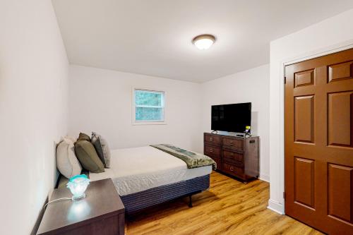 a bedroom with a bed and a tv and a door at Orange Street Haven in Wilmington