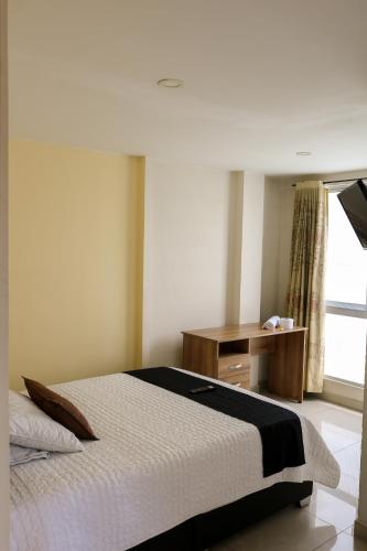 a bedroom with a bed and a desk and a window at Hotel Casa Botero 301 in Bogotá