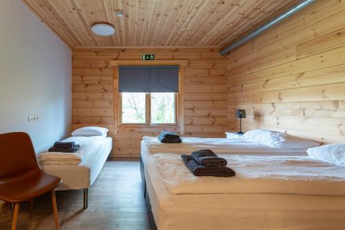 a room with three beds in a wooden cabin at Gladheimar Guest House in Blönduós
