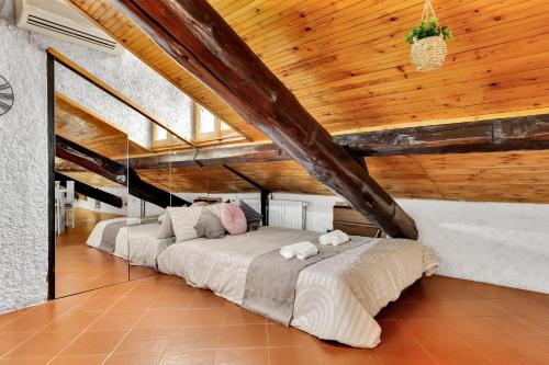 uma cama grande num quarto com tecto em madeira em Porta Venezia-Buenos Aires Chalet House in Shopping District Free Wifi Netflix em Milão