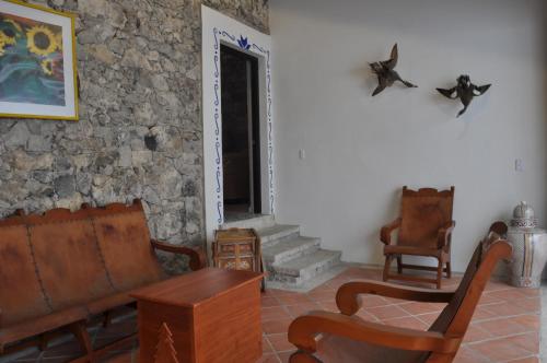 a living room with furniture and a stone wall at Hotel Boutique La Casona de Don Porfirio in Jonotla