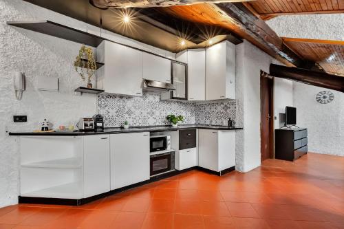 una cucina con armadi bianchi e pavimento piastrellato rosso di Porta Venezia-Buenos Aires Chalet House in Shopping District Free Wifi Netflix a Milano
