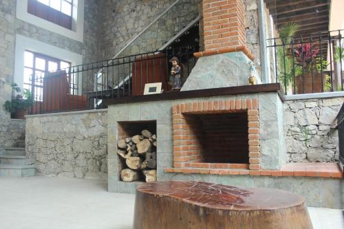 a brick fireplace with a log in front of it at Hotel Boutique La Casona de Don Porfirio in Jonotla