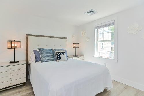 a white bedroom with a white bed and two lamps at Harbourtown Suites, Unit 216 in Plymouth