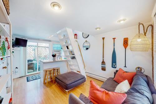 a living room with a couch and a stair case at Cozy Cape Condo in Provincetown