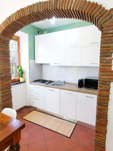 a kitchen with white cabinets and a table at CASA ARYA - Independent House - Near the Walls in Lucca