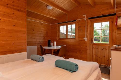 ein Schlafzimmer mit einem Bett in einem Holzzimmer in der Unterkunft Gladheimar Cottages in Blönduós