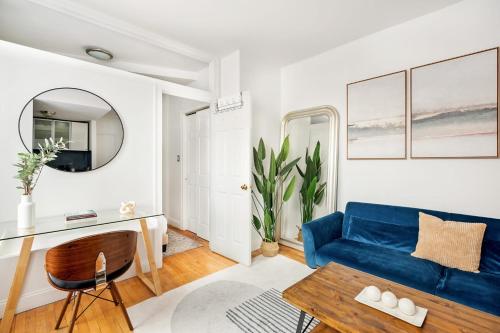 - un salon avec un canapé bleu et une table dans l'établissement 139-3E west village 1BR best value, à New York