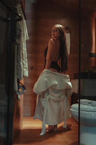 a woman in a dress sitting in a bathroom at Oculto refugio de bosque in Envigado