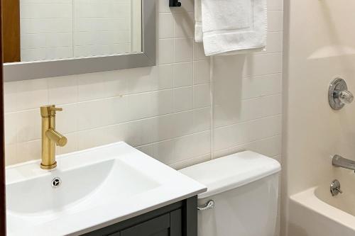ein weißes Bad mit einem Waschbecken und einem WC in der Unterkunft Harper Valley 01 in Kimberling City