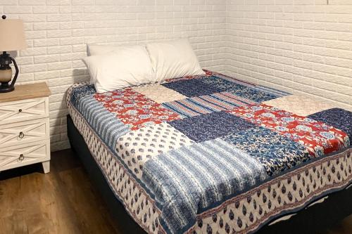 ein Bett mit einer Decke neben einer Ziegelwand in der Unterkunft Harper Valley 01 in Kimberling City