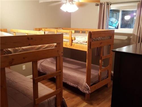 two bunk beds in a room with a window at Beach House Sleep 20 with VIP pkg, Bachelor Parties Welcomed in Lake Ozark
