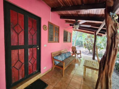 a living room with a pink wall and a door at Villas Pura Vibra in Potrero