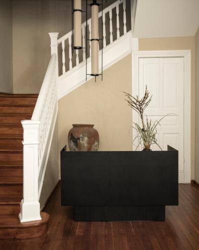 a staircase with a black console and a vase at Nima Local House Hotel & Spa in Mexico City