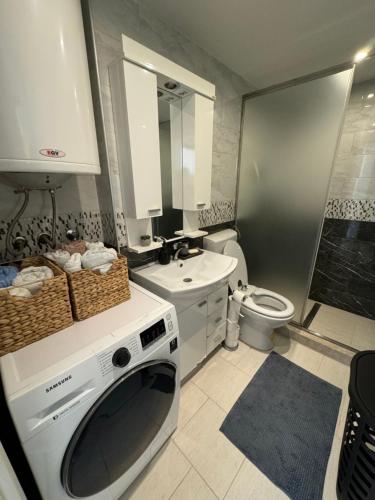 a bathroom with a washing machine and a sink at Urban Haven Sarajevo in Sarajevo