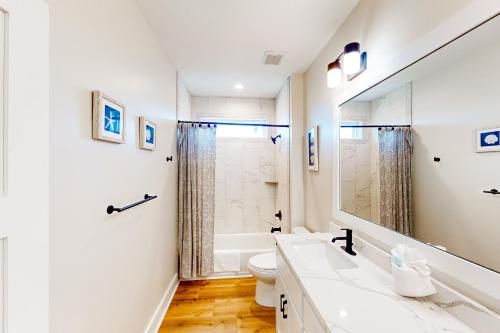 La salle de bains blanche est pourvue d'un lavabo et de toilettes. dans l'établissement La Maison Bleue, à Indian Pass