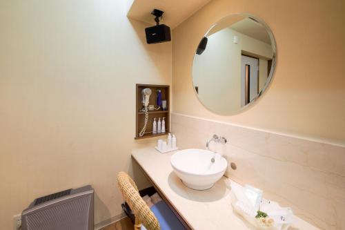 a bathroom with a sink and a mirror at Hotel Public Jam in Osaka