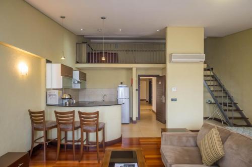 Una sala de estar y una cocina con un sofá y una mesa. en Taarifa Suites by Dunhill Serviced Apartments, en Nairobi