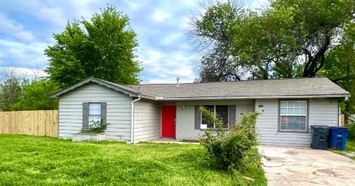 una pequeña casa blanca con una puerta roja en Private room pleasant grove, en Dallas