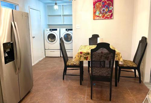 uma cozinha com uma mesa com cadeiras e uma máquina de lavar roupa em Private room pleasant grove em Dallas