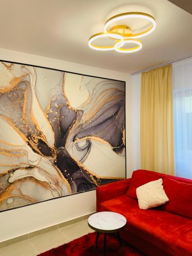 a living room with a red couch and a large painting at Bucharest luxury apartments Bragadiru in Bragadiru