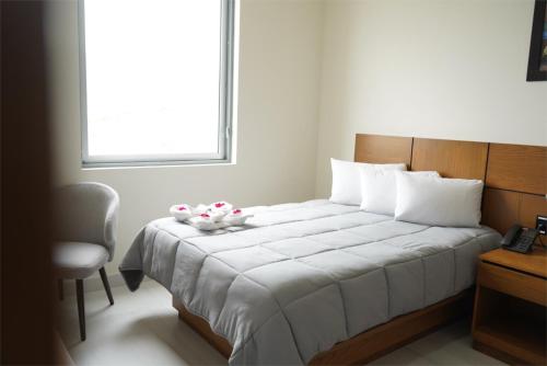 a bedroom with a white bed with a window at hotel vista valle in Tepic