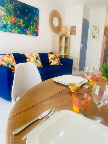 une table en bois avec des assiettes et de l'argenterie au-dessus dans l'établissement Appartement Neuf Cosy Centre Ville Quartier Haut, à Sète