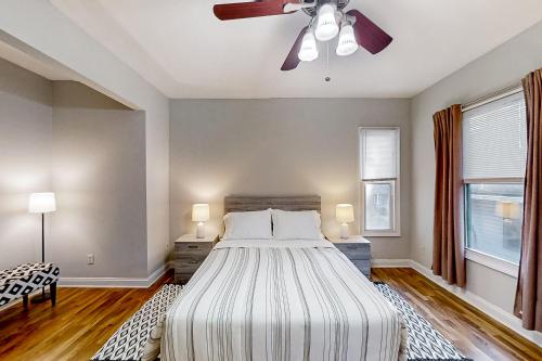 Heart of Paradise في جاكسونفيل: غرفة نوم بسرير ومروحة سقف
