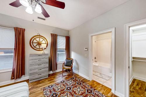 een slaapkamer met een stoel, een dressoir en ramen bij Heart of Paradise in Jacksonville