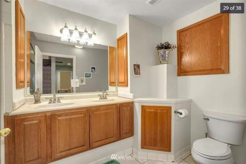 uma casa de banho com um WC, um lavatório e um espelho. em CALM Retreat and Event Center em Auburn
