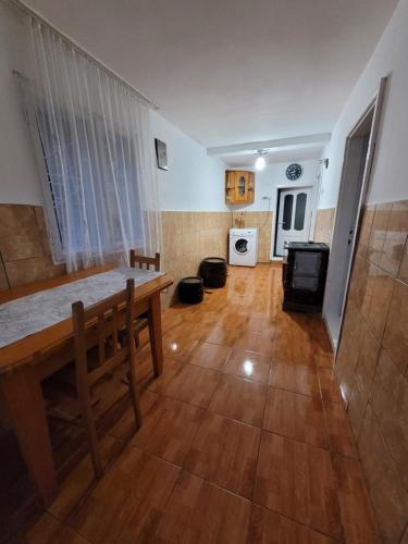 a living room with a wooden floor and a table at Casa Izvorul Rece in Cîmpeni