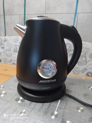 a black tea kettle with a clock on it at Etxalo, apartamento con terraza en Gorliz in Górliz-Elexalde