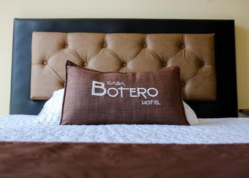 a pillow on a bed with a leather headboard at Hotel Casa Botero 305 in Bogotá