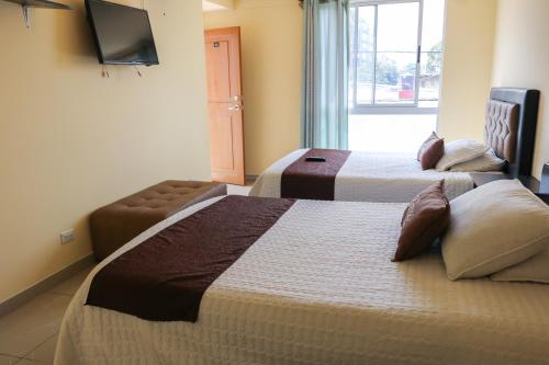 ein Hotelzimmer mit 2 Betten und einem TV in der Unterkunft Hotel Casa Botero 305 in Bogotá