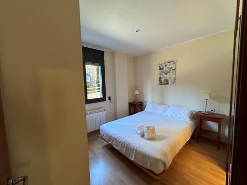 um quarto com uma cama branca e uma janela em Apartament La Solana del Tarter 5p - El Tarter - Zona Grandvalira em Sant Pere