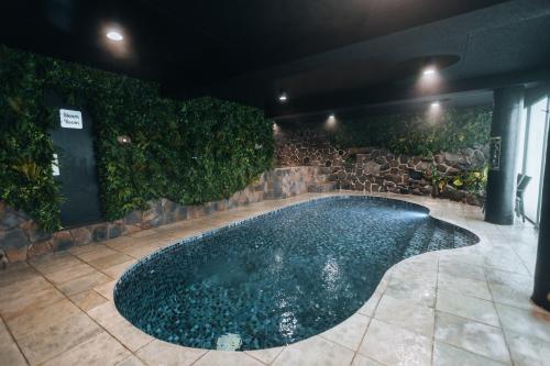 uma piscina num quarto com uma parede de pedra em Falls Creek Hotel em Falls Creek