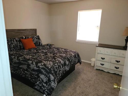 a bedroom with a bed and a window and a dresser at The Oasis - C in Clovis